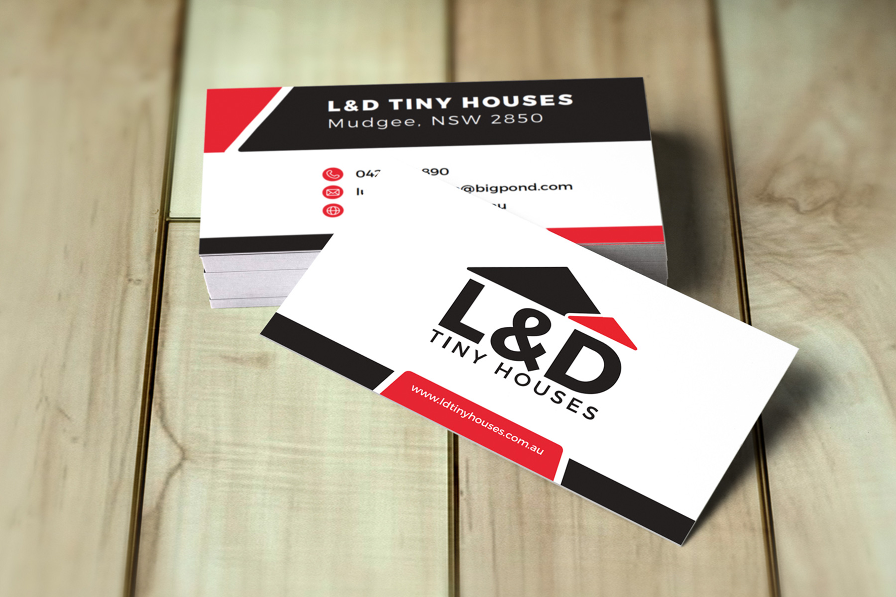 L&D Tiny Houses business cards on a wooden floor